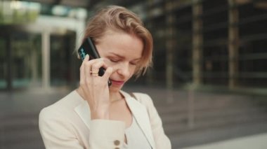 Close up, businesswoman talking on the cellphone, looking at her watch