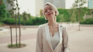 Businesswoman crosses her arms, looks at the camera