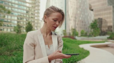 Businesswoman uses cellphone, sends voice message