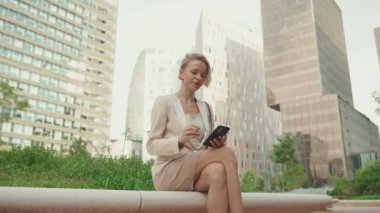 Businesswoman with blond hair typing on cellphone