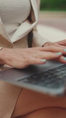 VERTICAL VIDEO: Close-up of female hands working on laptop, pc
