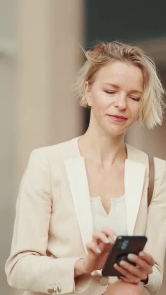 Vertical Video Επιχειρηματίας Ξανθά Μαλλιά Φορώντας Μπεζ Κοστούμι Χρησιμοποιώντας Κινητό — Αρχείο Βίντεο