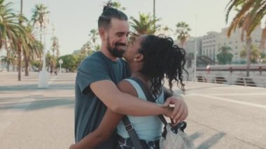Happy interracial family hugging and kissing outside