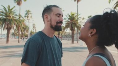 Loving interracial couple hugging and kissing outside