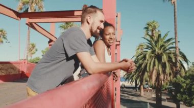 Close-up of an interracial couple standing on bridge