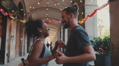 Happy interracial couple dancing outdoors