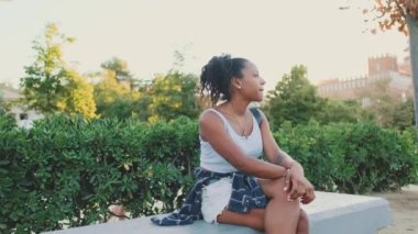 Young mixed race woman sitting on park bench