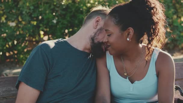 Happy Smiling Interracial Couple Kissing While Sitting Bench — 图库视频影像