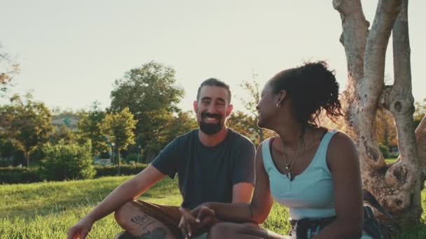 Loving Interracial Couple Holding Hands While Sitting Grass Lawn — Video