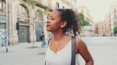 Close up, young mixed race woman walks along the street of the old city and looks around