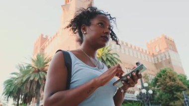Young mixed race woman is using cell phone, looking at the application map on her smartphone