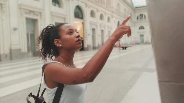 Young Mixed Race Woman Stands Railway Station Looks Information Board — Vídeo de stock