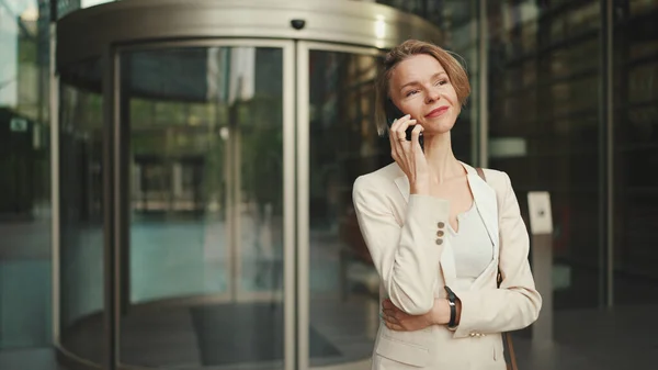 Close up, businesswoman talking on the cellphone on business center background