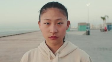 Close up of asian girl wearing sportswear looking at camera at morning time
