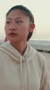 VERTICAL VIDEO: Asian girl wears sportswear, climbs the stairs at morning time