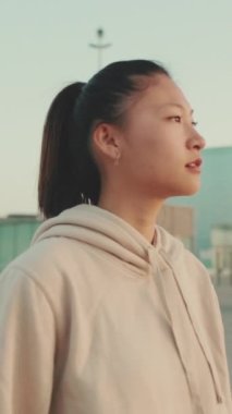 VERTICAL VIDEO: Asian young athletic woman in sportswear walking outdoors at morning time