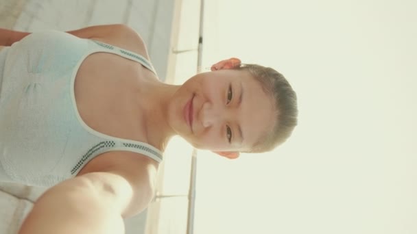 Vertical Video Smiling Asian Girl Sports Top Makes Selfie While — ストック動画