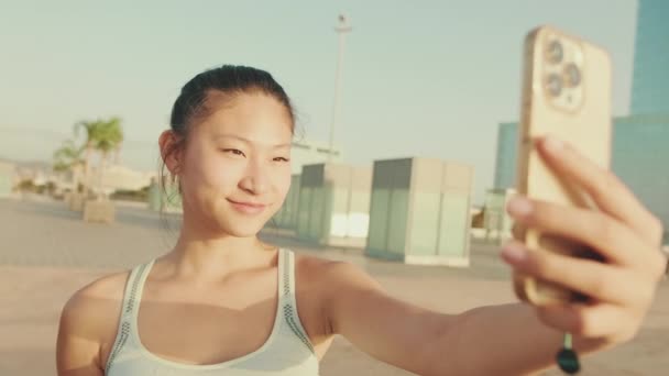 Asian Girl Sports Top Makes Selfie While Standing Embankment Modern — 비디오