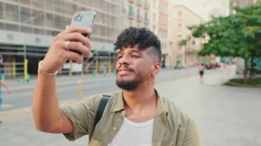 Close up, young man dressed in an olive-colored shirt takes photo on the street of the old city