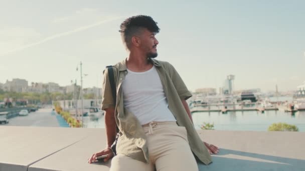 Young Smiling Man Dressed Olive Colored Shirt Sits Promenade Port — Vídeos de Stock