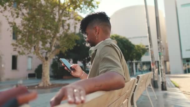 Young Man Beard Wearing Olive Colored Shirt Headphones Sits Bench — Vídeos de Stock