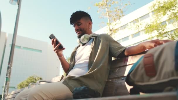 Young Man Beard Wearing Olive Colored Shirt Headphones Sits Bench — Vídeo de stock