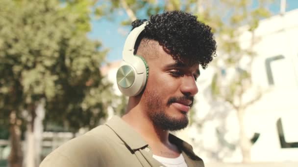 Close Young Man Headphones Turns His Head Looks Camera Smiles — Αρχείο Βίντεο