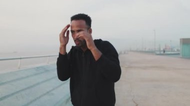 Genç sakallı erkek atlet boksör setin üzerinde dururken yumruk tekniği uyguluyor.