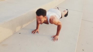 Genç sakallı erkek sporcu antrenman yapıyor, barajda şınav çekiyor.