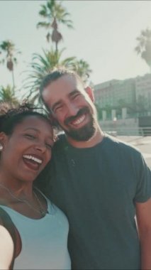 VERTICAL VIDEO: Close-up of interracial smiling couple in love taking selfie