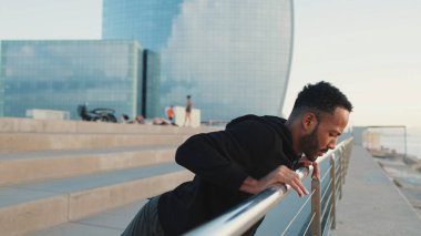 Yaklaş, genç sakallı erkek sporcu. Rıhtımda şınav çekiyor.