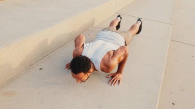 Genç sakallı erkek sporcu antrenman yapıyor, barajda şınav çekiyor.