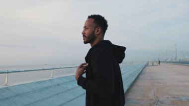 Genç sakallı erkek sporcu sette yürüyor.