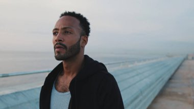 Genç sakallı erkek sporcu sette yürüyor.