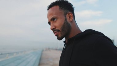 Genç sakallı erkek sporcu sette yürüyor.