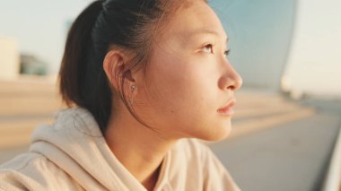 Kapat şunu, spor giysili Asyalı kız sabah deniz dibinde dikiliyor.