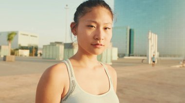 Close up, asian girl in sports top looks at the camera