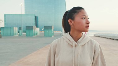 Asian girl wears sportswear walking outside at morning time