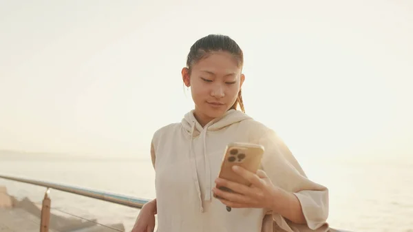 Close Asian Girl Sportswear Uses Phone While Standing Embankment Morning —  Fotos de Stock