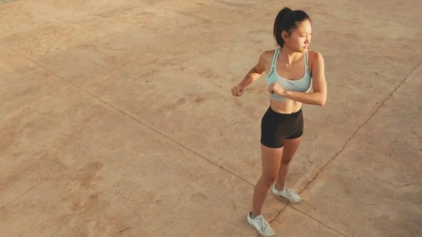 Asian girl in sports top does workout, stretching and gymnastics at morning time. View from above