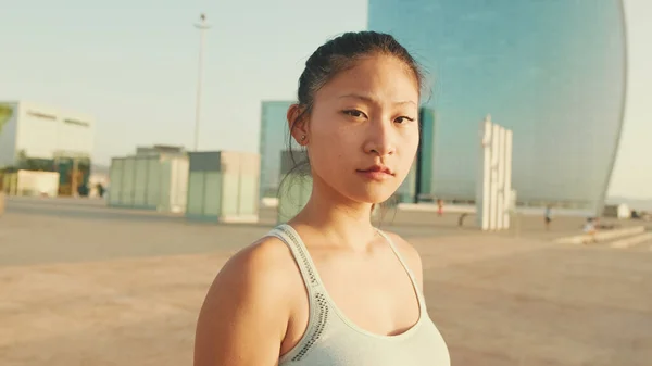 Close up, asian girl in sports top looks at the camera