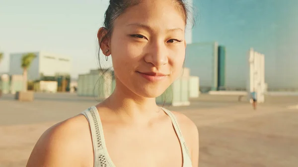 Close up, asian girl in sports top looks at the camera