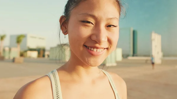 Close up, asian girl in sports top looks at the camera