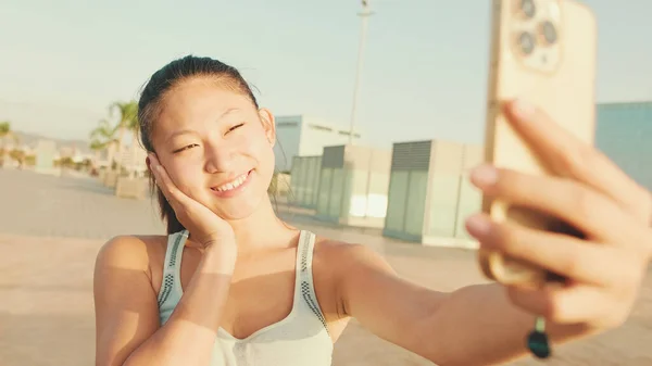 Asian Girl Sports Top Makes Selfie While Standing Embankment Modern — Zdjęcie stockowe