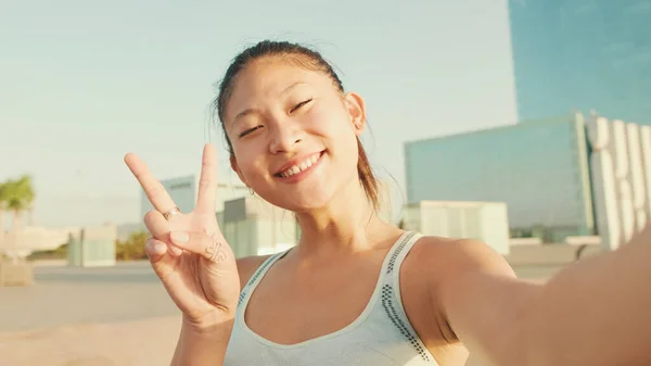 Smiling Asian Girl Sports Top Makes Selfie While Standing Embankment — Zdjęcie stockowe