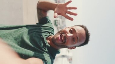 Limanda arka planda yatlarla otururken telefondan video görüşmesi yapan mutlu genç bir adam.