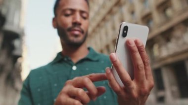 Telefonu kullanan genç adamın ellerini yakın plan çek.