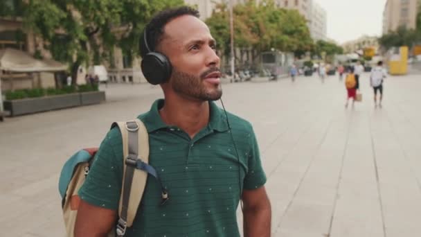 Junger Mann Spaziert Über Den Platz Der Altstadt Hört Musik — Stockvideo