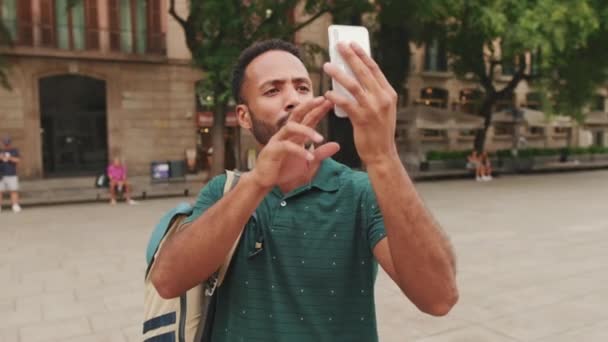 Młody Człowiek Turysta Robi Zdjęcia Przez Telefon Komórkowy Stojąc Placu — Wideo stockowe