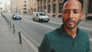 Sokakta yürüyen genç adam eski kasabanın arka planında